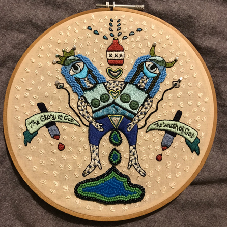 Embroidery of a two-torsoed being with the words "The Glory of God" and "The Wrath of God" 